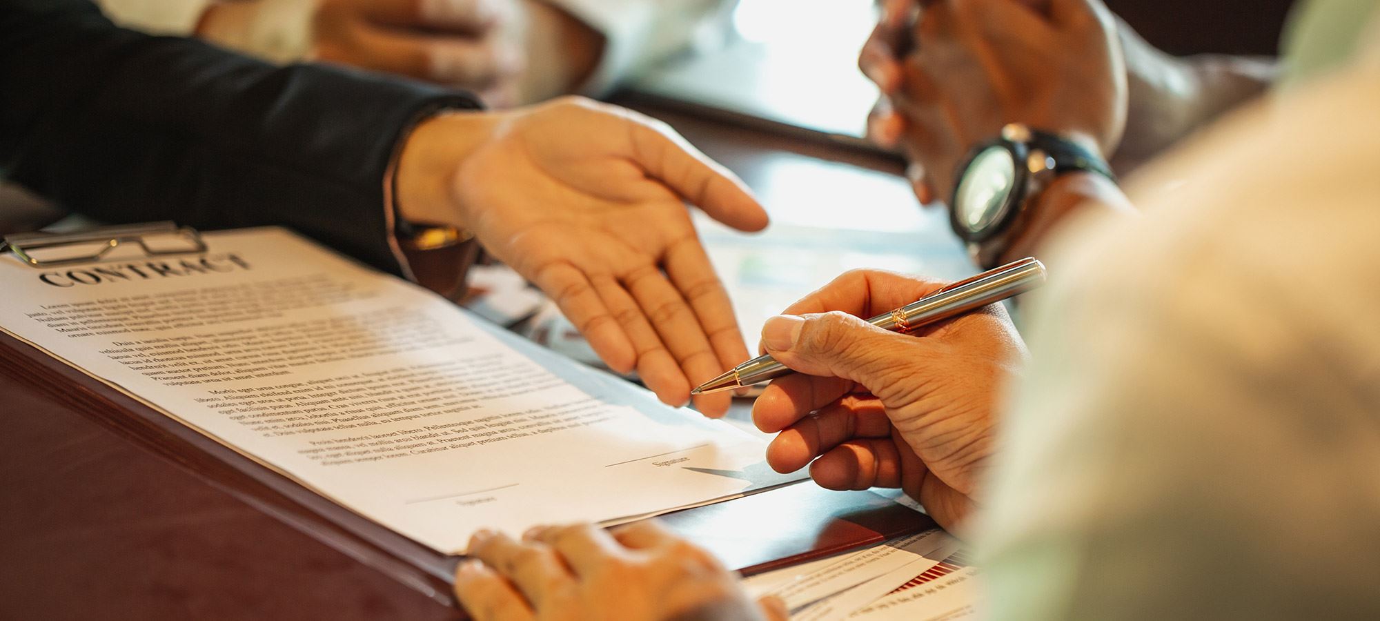 Customer signing a loan agreement, while the loan officer stands by.