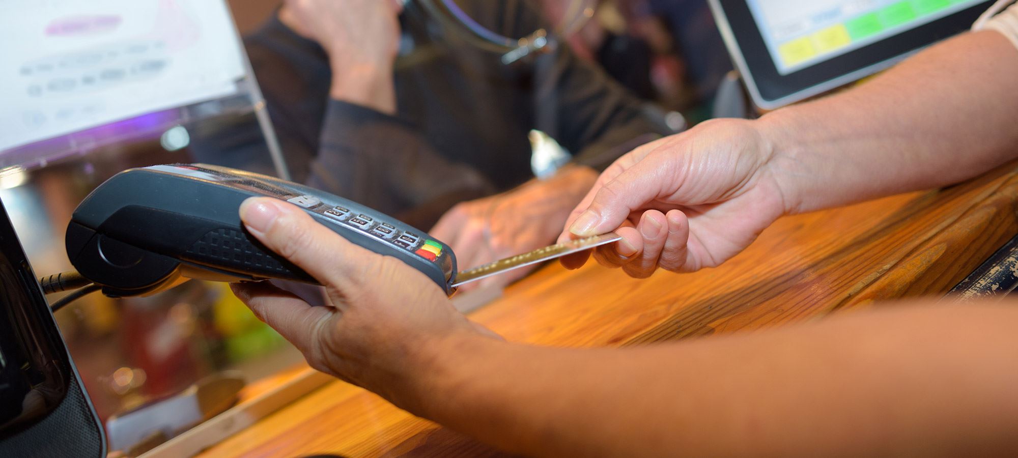 Person using a credit card reader at the counter.